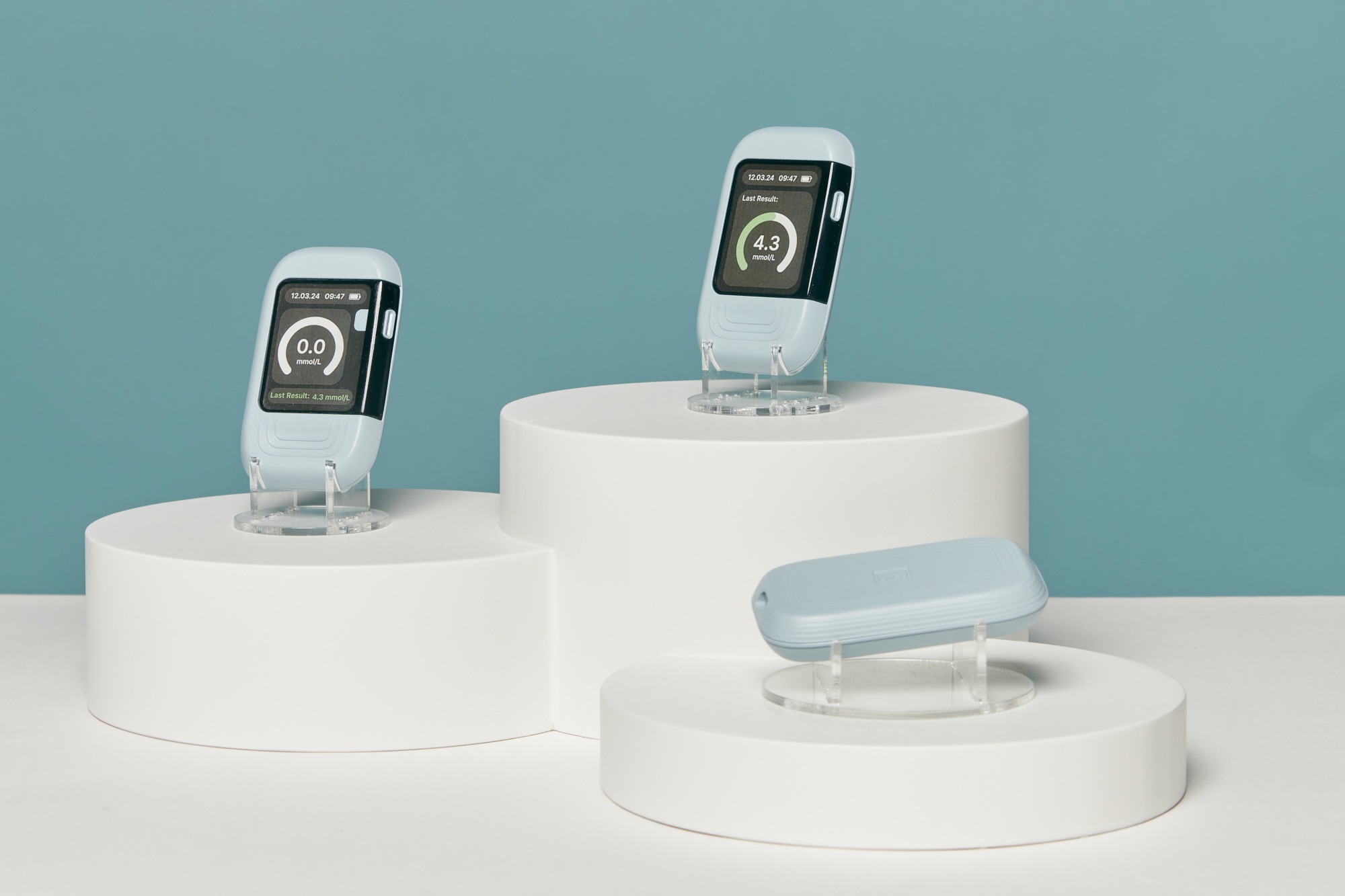 Three final Kali prototypes displayed on white plinths against a teal wall.