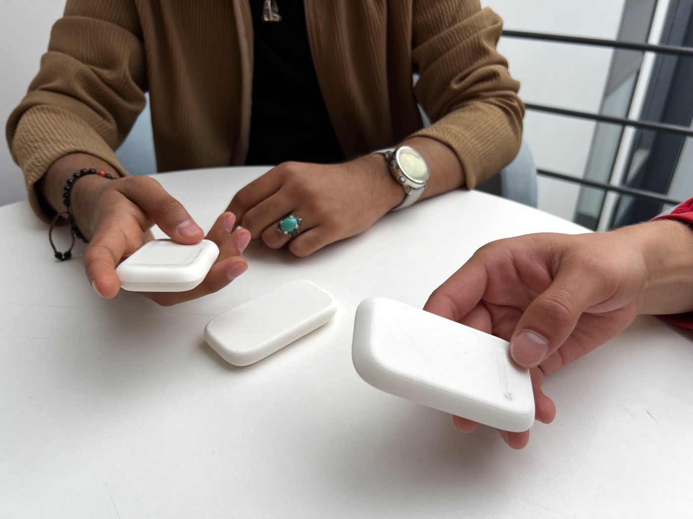 Two people handling white foam models of different sizes during user testing.